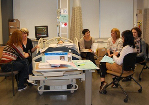 Doris Leung monitors the simulation and prepares feedback on communication techniques used.