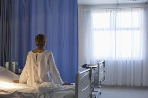 Patient wearing gown on hospital bed