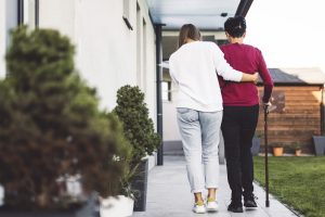 A caregiver helps an elderly lady