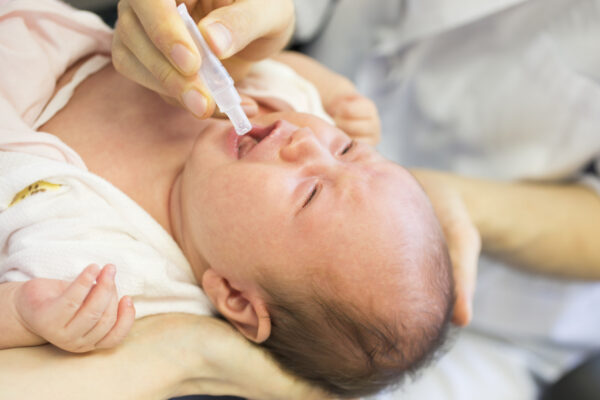 Infant receiving vaccination orally.